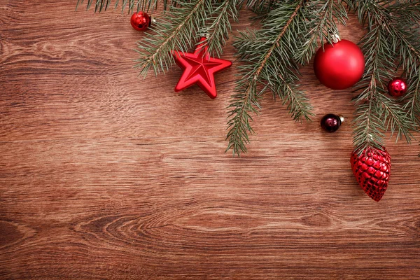 Adornos navideños y rama de abeto sobre un fondo rústico de madera. Tarjeta de Navidad. Feliz Año Nuevo. Vista superior con espacio de copia — Foto de Stock