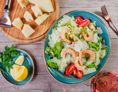 Karides salatası parmesan peyniri, kruton, domates, karışık yeşillik, marul ve ahşap arka plan üzerinde şarap ile. Sağlıklı gıda. Üstten Görünüm