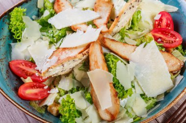 Salata tavuk göğsü, parmesan peyniri, kruton, domates, karışık yeşillik, marul ve şarap hafif ahşap zemin üzerinde. Maddeler tablosundaki. Üstten Görünüm