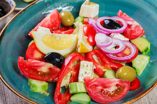 Griechischer Salat aus Bio-Gemüse mit Tomaten, Gurken, roten Zwiebeln, Oliven, Feta-Käse und einem Glas Wein auf Holzgrund. Ansicht von oben — Stockfoto