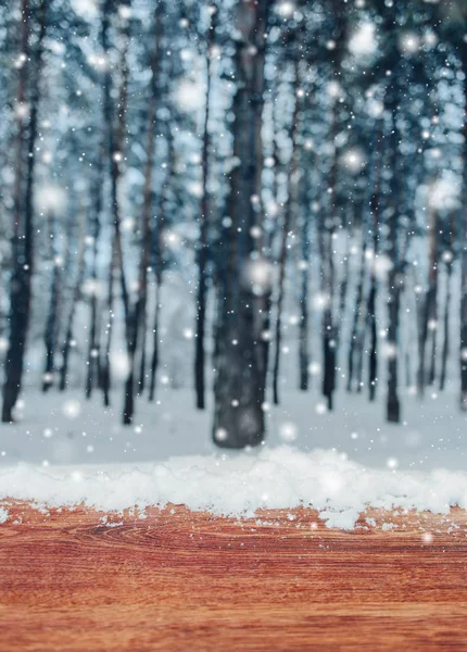 Ξύλινο τραπέζι με χιόνι τόπου και Χριστουγεννιάτικο φόντο με έλατα και θολή φόντο του χειμώνα. Παγωμένο χειμωνιάτικο τοπίο στο χιονισμένο δάσος — Φωτογραφία Αρχείου