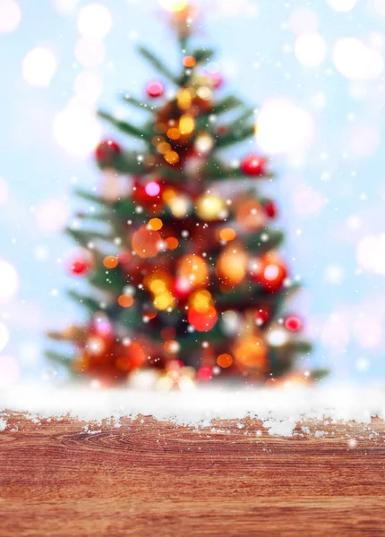 Houten tafel met sneeuw plaats en kerstboom achtergrond met wazig, vonken, gloeien. Happy New Year en Xmas thema — Stockfoto