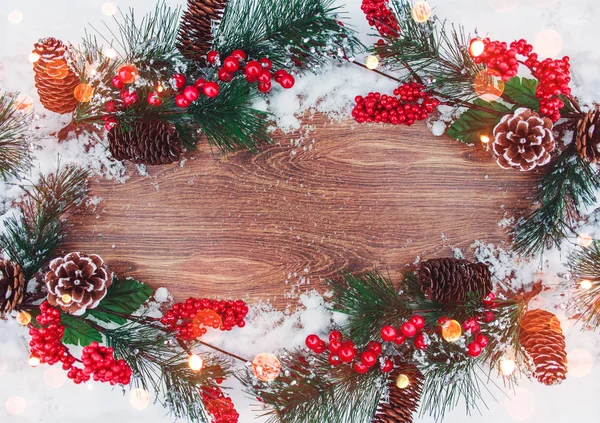 Weihnachtsdekoration, Tannenzweig mit Zapfen und Schnee auf hölzernem Hintergrund. Frohe Weihnachten und ein gutes neues Jahr — Stockfoto