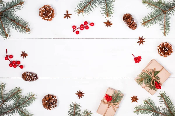 Julebaggrund med julegave, grangrene, kogler, snefnug, røde dekorationer. Xmas og Godt Nytår sammensætning. Sted for tekst. Flad lå, øverste udsigt - Stock-foto