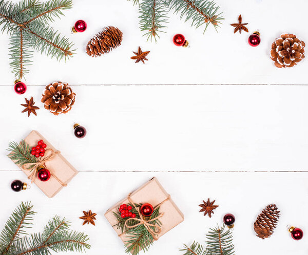 Christmas background with Christmas gift, fir branches, pine cones, snowflakes, red decorations. Xmas and Happy New Year composition. Place for text. Flat lay, top view