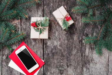 Noel arka plan ile smartphone, Noel hediyesi, ahşap arka plan dallarda köknar çam dalları ile. Noel ve mutlu yeni yıl kompozisyon. Düz yatıyordu, en iyi görünümü