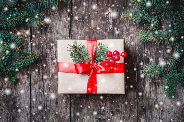 Caja de regalo de Navidad con cinta roja, ramas de abeto, copos de nieve sobre fondo de madera. Navidad y Feliz Año Nuevo composición. Piso tendido, vista superior — Foto de Stock