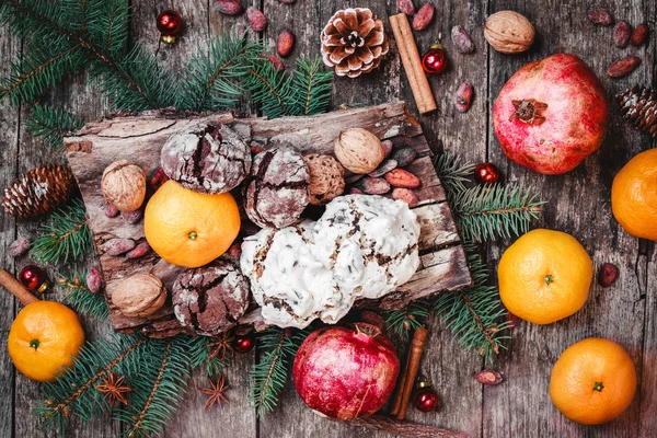 Vánoční přání. Vánoční dárky, čokoládové Cookies, granátová jablka, mandarinky, oříšky, kakaové boby, větve jedle na dřevěné zasněžené pozadí. Vánoce a šťastný nový rok složení. Pohled shora, Selektivní ostření — Stock fotografie