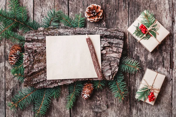 クリスマス プレゼント、樹皮のテクスチャー、鉛筆、モミ枝、松ぼっくり、赤い装飾の木製の背景にクリスマスの手紙。クリスマスと新年のカード。フラット横たわっていた、トップ ビュー — ストック写真