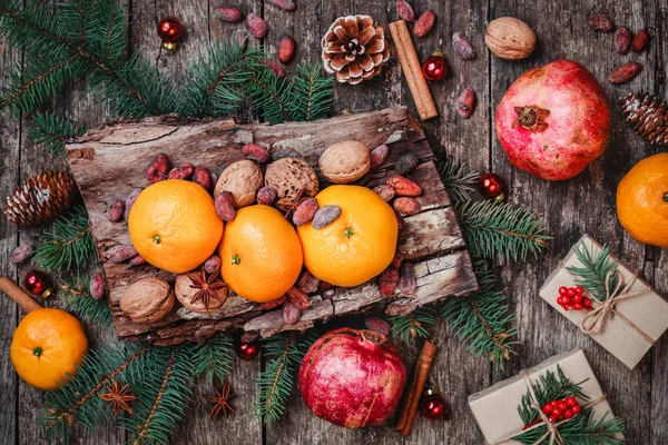 Vánoční přání. Soubory cookies čokoláda, čaj, granátové jablko, mandarinky, oříšky, kakaové boby, větve jedle na dřevěné pozadí. Téma Vánoce a šťastný nový rok. Pohled shora, Selektivní ostření — Stock fotografie