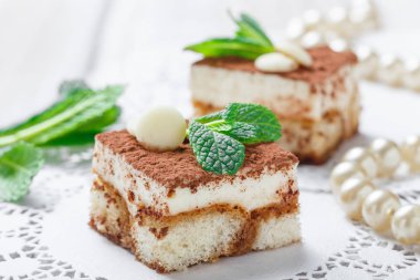 Mini kek tiramisu ile beyaz çikolata kakao ve şekerleme ışık arka plan üzerine kapatın. Lezzetli tatlı ve şeker çubuğu.