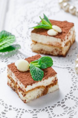 Mini kek tiramisu ile beyaz çikolata kakao ve şekerleme ışık arka plan üzerine kapatın. Lezzetli tatlı ve şeker çubuğu.