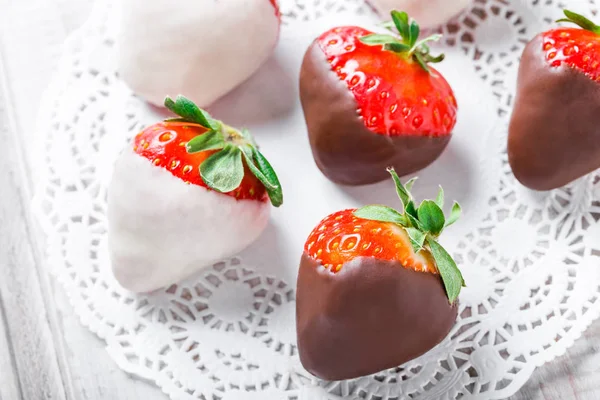 Färska jordgubbar doppade i mörk och vit choklad på ljus bakgrund närbild. Läcker dessert och godis bar. Ovanifrån — Stockfoto