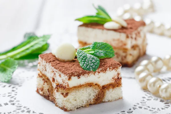 Mini gebak tiramisu met witte chocolade, cacao en snoepjes op lichte achtergrond close-up. Heerlijk dessert en snoep bar. — Stockfoto