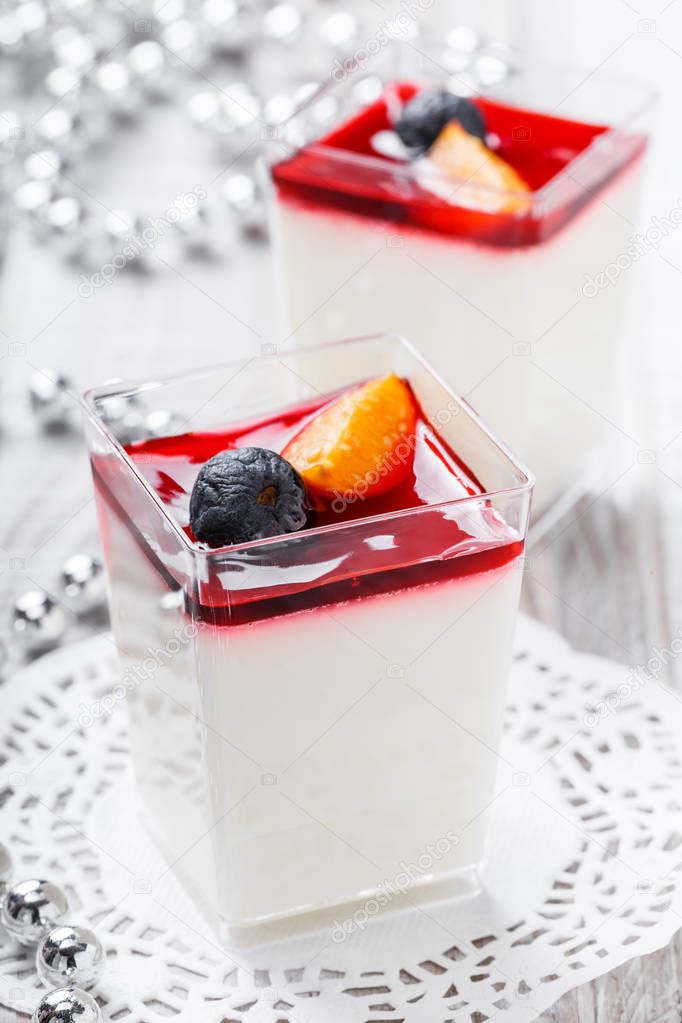 Tasty mousse with jelly and berries in a glass on light background close up. Delicious dessert and candy bar. Top view