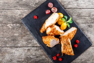 Izgara tavuk göğsü sebze ve meyveleri ahşap arka plan üzerinde taş arduvaz arka plan üzerine kapatın. Sıcak et yemekleri. Üstten Görünüm