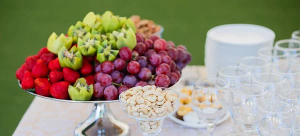 Frutta fresca sul piatto. Fragole, kiwi, uva e anacardi sul tavolo del banchetto di catering. Focus selettivo . — Foto Stock