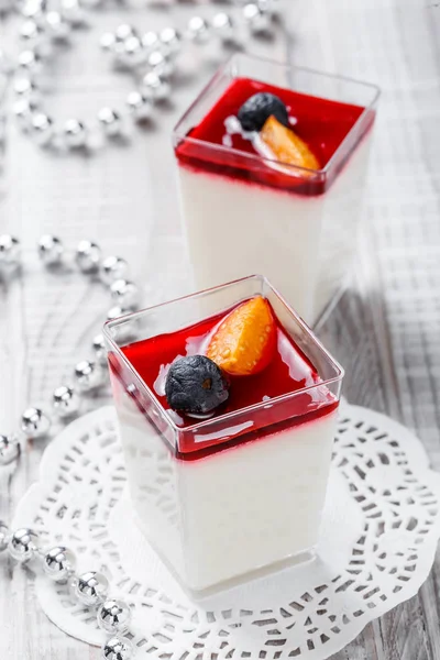 Mousse saporita con gelatina e bacche in un bicchiere su fondo chiaro da vicino. Delizioso dessert e barretta di cioccolato. Vista dall'alto . — Foto Stock