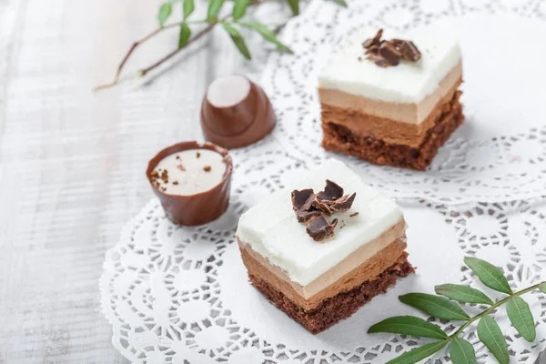 Mini koláčky s bílou čokoládou, kakaem a cukroví na světlém pozadí zblízka. — Stock fotografie
