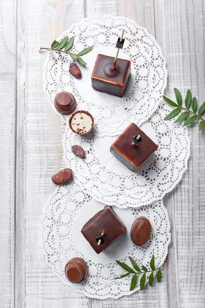 チョコレート プラリネ、木製の背景にカカオ豆とチョコレートのスフレのお菓子デザートをクローズ アップ。トップ ビュー — ストック写真