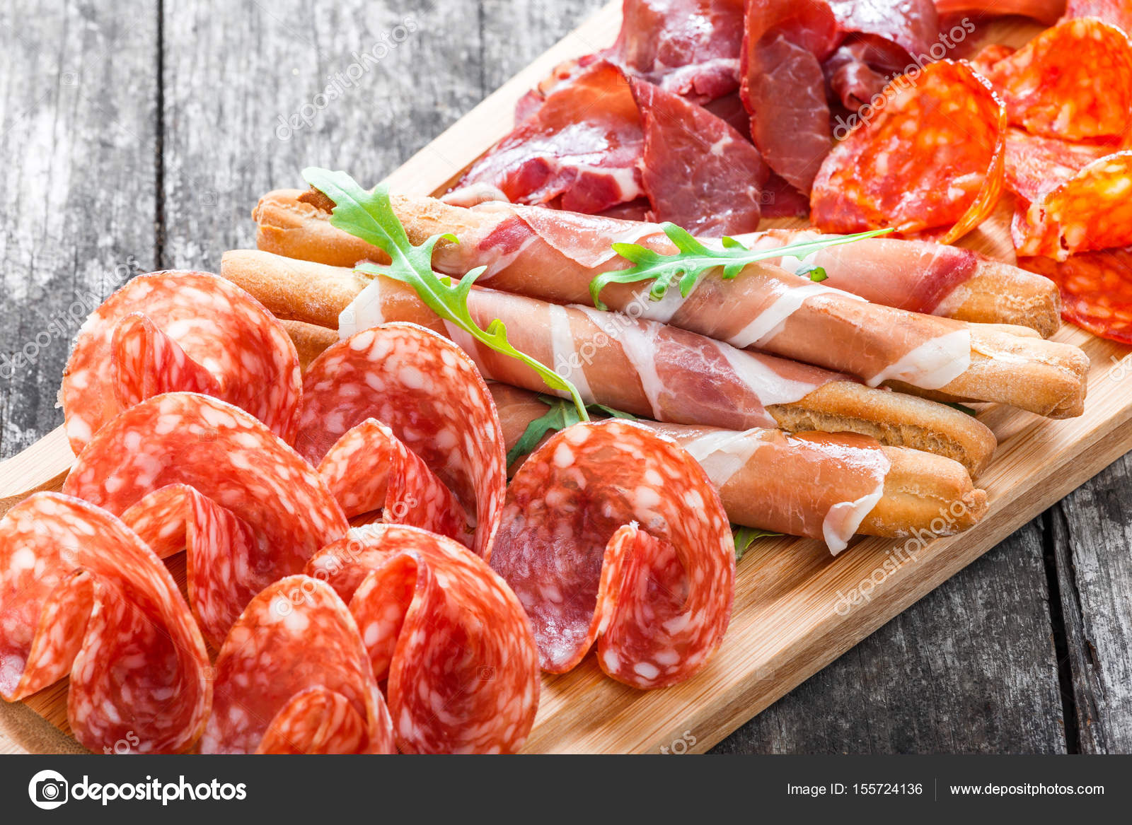 Antipasto platter cold meat plate with grissini bread sticks