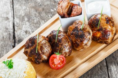 Sulu lezzetli et pirzola ve Mısır unu, yulaf lapası Polenta, ahşap arka plan üzerinde kesme tahtası üzerinde keçi peyniri ile Mısır. Sıcak et yemekleri. Üstten Görünüm