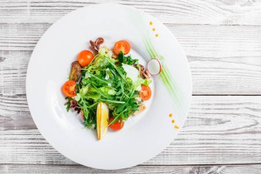 Deniz ürünleri salatası midye, mürekkep, ahtapot, roka, marul ve domates ahşap zemin üzerine kapatın. Akdeniz yemekleri