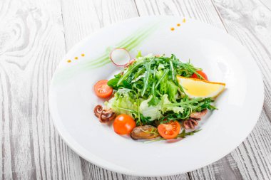 Deniz ürünleri salatası midye, mürekkep, ahtapot, roka, marul ve domates ahşap zemin üzerine kapatın. Akdeniz yemekleri