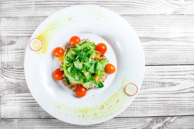 Taze salata tavuk göğsü, Bebek ıspanak, marul, domates ve peynirle ahşap arka plan üzerinde kapat