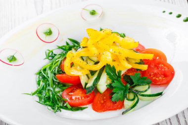 Taze salata domates, salatalık, turp, tatlı biber ve soğan bir plaka üzerinde ahşap arka plan ile kapatın. Üstten Görünüm