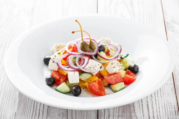 Grekisk sallad med färska grönsaker, oliver och fetaost på trä bakgrund närbild. Ovanifrån — Stockfoto