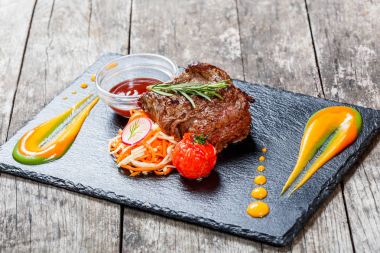 Taze salata ve Barbekü sos ahşap arka plan üzerinde taş arduvaz arka plan üzerinde ızgara sığır eti biftek kapatın. Sıcak et yemekleri. Üstten Görünüm