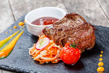 Taze salata ve Barbekü sos ahşap arka plan üzerinde taş arduvaz arka plan üzerinde ızgara sığır eti biftek kapatın. Sıcak et yemekleri. Üstten Görünüm