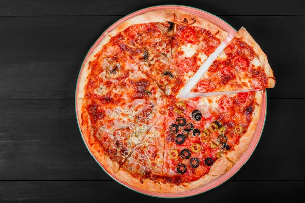 Pizza mista Comida italiana com frango, tomate, cogumelos, presunto, salame, azeitona e queijo sobre fundo de madeira escura. Pizza caseira. Vista superior — Fotografia de Stock