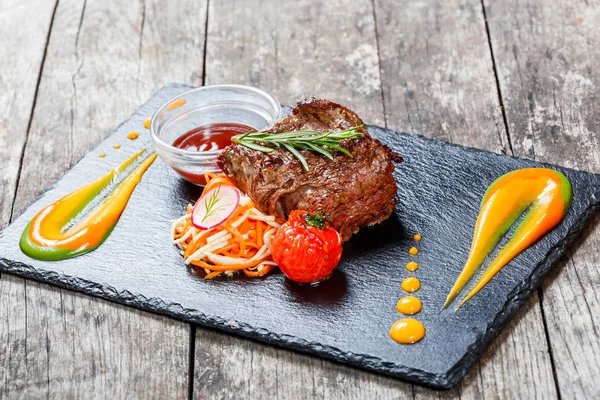 Taze salata ve Barbekü sos ahşap arka plan üzerinde taş arduvaz arka plan üzerinde ızgara sığır eti biftek kapatın. Sıcak et yemekleri. Üstten Görünüm