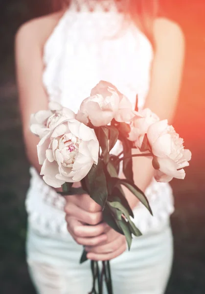 Mani della ragazza che tengono mazzo di peonie fiori all'aperto. Concentrazione selettiva. Tonificante — Foto Stock