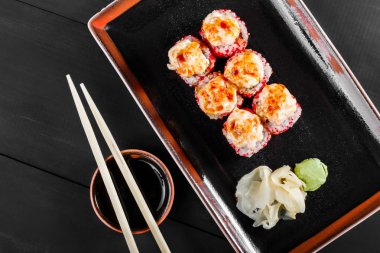 Suşi Roll - Maki Sushi kırmızı havyar, yılan balığı, avokado ve koyu ahşap zemin üzerine peynir ile. Üstten Görünüm. Japon mutfağı