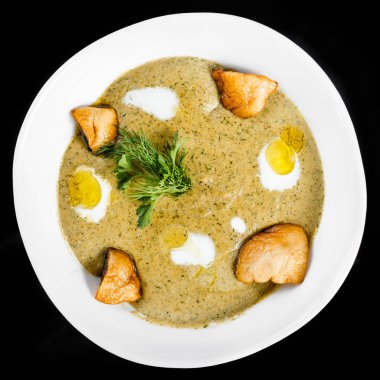 Kremalı çorba kase mantar, otlar ve krem, izole üzerinde siyah arka plan, sağlıklı gıda ile. Üstten Görünüm