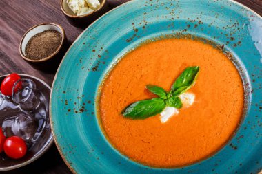 Domates gazpacho çorbası fesleğen, beyaz peynir, buz kase koyu ahşap zemin, İspanya mutfağı üzerine. Üstten Görünüm