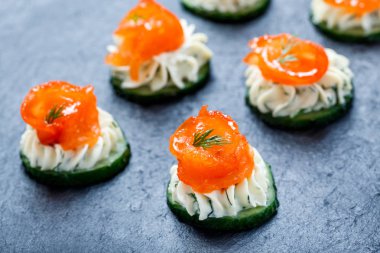 Meze kanepe somon, salatalık ve kayrak taş zemin üzerine krem peynir ile kapatın. Lezzetli aperatifler, sandviçler, crostini, bruschetta, parti ya da piknik zamanında antipasti. Üstten Görünüm