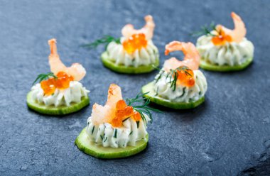 Meze kanepe kırmızı havyar, karides ve kayrak taş zemin üzerine krem peynir ile kapatın. Lezzetli aperatifler, sandviçler, crostini, bruschetta, parti ya da piknik zamanında antipasti. Üstten Görünüm