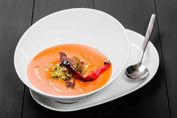 Soupe de tomates, soupe de poivrons rouges, sauce à l'huile d'olive, viande et cornichons dans un bol sur fond de bois noir, nourriture saine. Vue du dessus — Photo