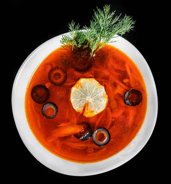 Soupe avec viande, olives, herbes et citron dans un bol, isolé sur fond noir, nourriture maison. Soupe russe traditionnelle - solyanka — Photo