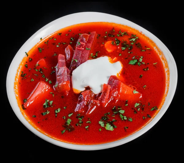 La sopa tradicional ucraniana y rusa de remolacha - borscht en la escudilla con la crema agria y las hierbas, aislado sobre el fondo negro, la comida sana. Vista superior — Foto de Stock