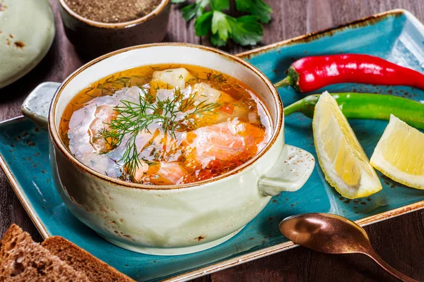 Рибний суп з лососем і креветками, кріп, картопля, лимон, перець і хліб на темному дерев'яному фоні, здорова їжа — стокове фото
