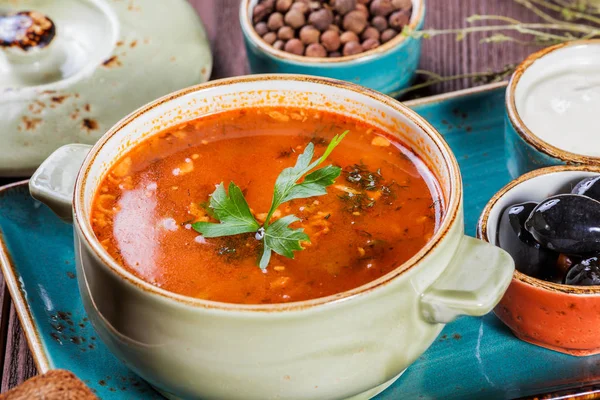 Soppa med kött, oliver, örter, citron, gräddfil i skål, svart bröd och kryddor på mörk trä bakgrund, hemlagad mat. Traditionell rysk soppa - solyanka. Ovanifrån — Stockfoto