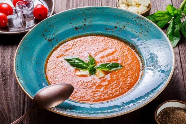 Томатний суп приготування гаспачо в миску з базиліком, сир фета, лід на темному тлі дерев'яні, іспанської кухні. Вид зверху — стокове фото