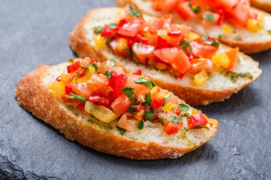 Meze bruschetta ciabatta ekmeği kayrak taş zemin üzerine doğranmış sebze ile kapatın. Lezzetli aperatifler, sandviçler, crostini, kanepe, parti ya da piknik zamanında antipasti. Üstten Görünüm