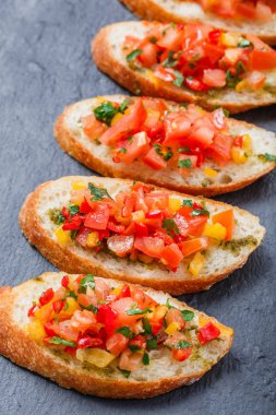 Meze bruschetta ciabatta ekmeği kayrak taş zemin üzerine doğranmış sebze ile kapatın. Lezzetli aperatifler, sandviçler, crostini, kanepe, parti ya da piknik zamanında antipasti. Üstten Görünüm