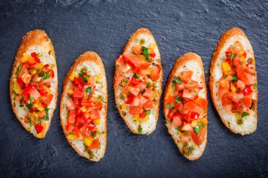 Meze bruschetta ciabatta ekmeği kayrak taş zemin üzerine doğranmış sebze ile kapatın. Lezzetli aperatifler, sandviçler, crostini, kanepe, parti ya da piknik zamanında antipasti. Üstten Görünüm